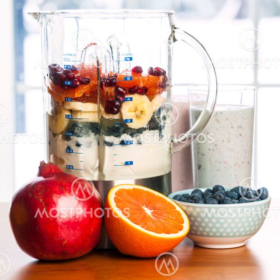 Making smoothies in blender with fruit and yogurt