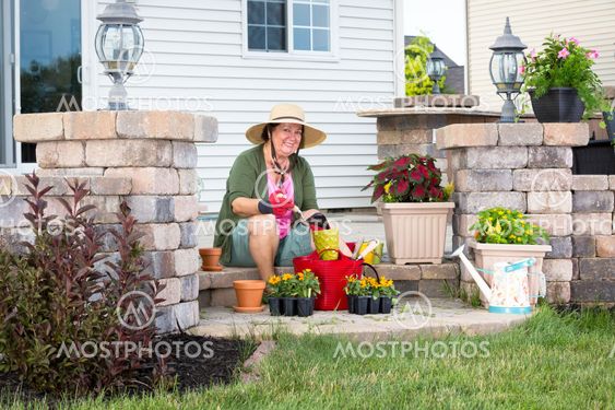Happy elderly Grandma potting up plants
