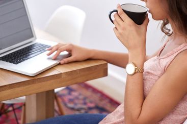 Research, coffee and woman at laptop in home office for...