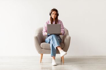 Young Caucasian woman having video call, using laptop...