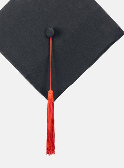 Black academic cap with long tassel isolated on white