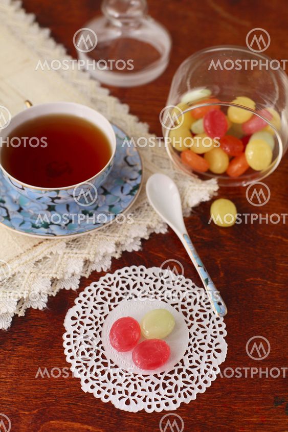 Tea with coloured sugar candies in a glass can