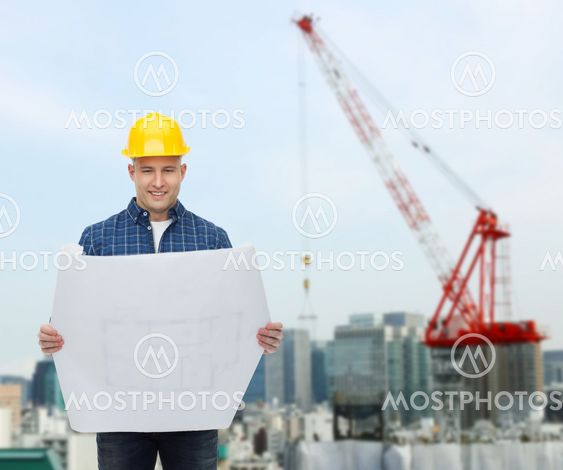 smiling male builder in helmet with blueprint