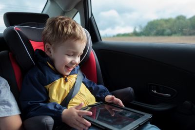 Happy boy playing with touchpad in the car