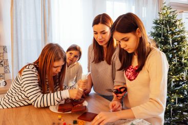 A smiling mother and daughter cook Christmas cookies...