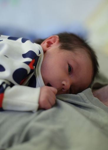 Little baby lying on father's hands. Childhood, love,...