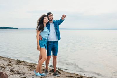 handsome boyfriend gesturing and hugging his girlfriend...