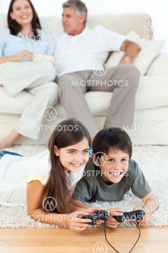Children playing videogames while parents are talking