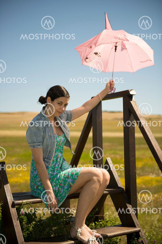 Beautiful adult smelling flowers on sunny field enjoying herself
