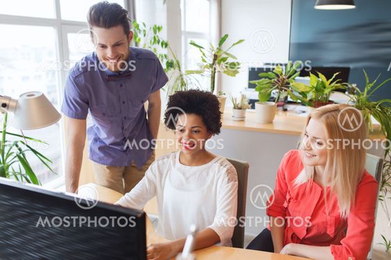 happy creative team with computer in office