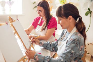 Close-up of young women in casual clothes at a painting...