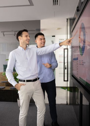 Cheerful male business colleagues discussing product...