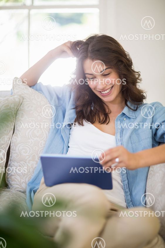 Woman using a digital tablet in living room