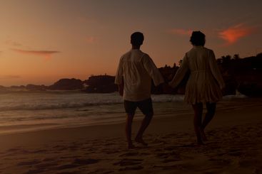 Sunset, holding hands and couple with walking on beach,...