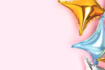 Banner with colourful foil star balloons on a pink...