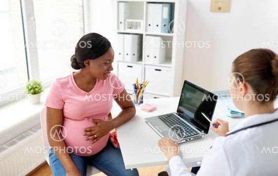 doctor with laptop and pregnant woman at clinic