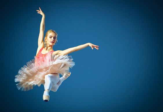 Beautiful female ballet dancer on a grey background....
