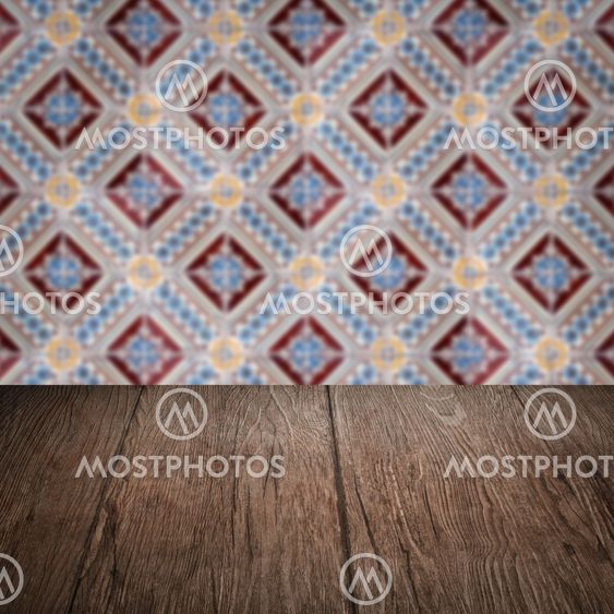 Wood table top and blur vintage ceramic tile pattern wall