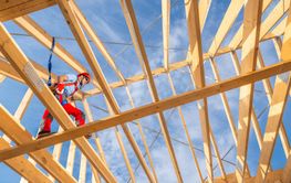 Construction Worker Safely Navigating Wooden Framework at...