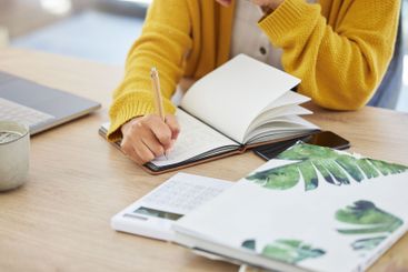 Notebook, writing and hand of woman in home with study...