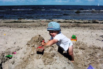 Litet barn leker på stranden
