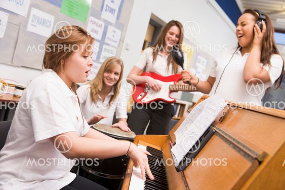 Schoolgirls playing musical instruments in music class