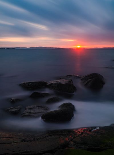 Tranquil Beach at Sunset: Dramatic Afterglow over Scenic...