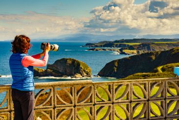 Tourist with camera on Asturias coast, Spain