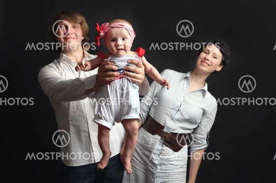 Parents hold their baby studio