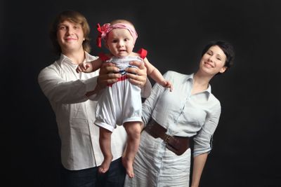 Parents hold their baby studio