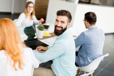 Portrait of  young bearded  businessman and his team