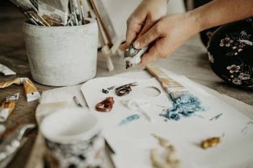 Paint tube, paper and hands mixing color, creative...