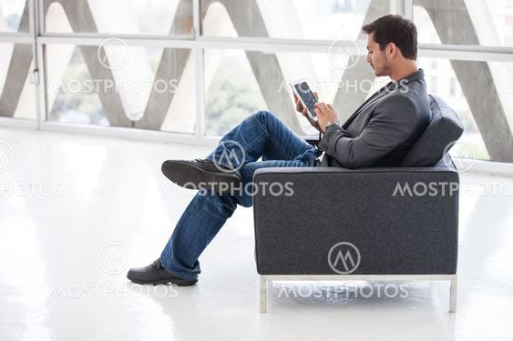 Good looking man in his 20s working on a mini think pad