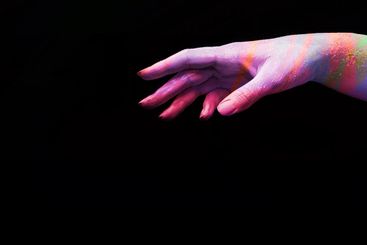 A beautiful multicoloured woman's hand reaches for present