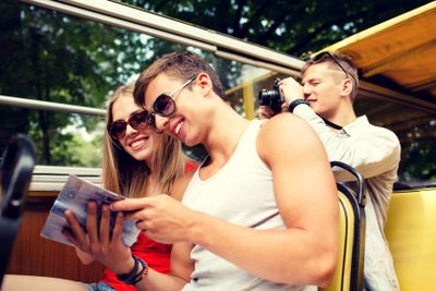 smiling couple with book traveling by tour bus