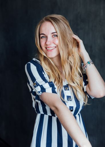Creaming blonde woman in summer striped dress smiling