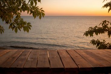 Photo of a wooden table with a view of the ocean and trees