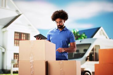 The Smiling Professional Handyman Holding a Delivery...