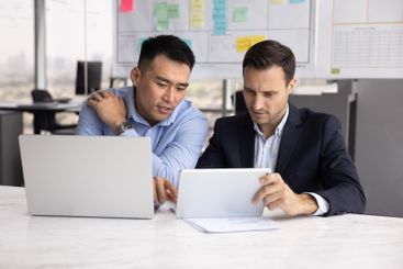 Busy Asian and Caucasian male business colleagues...