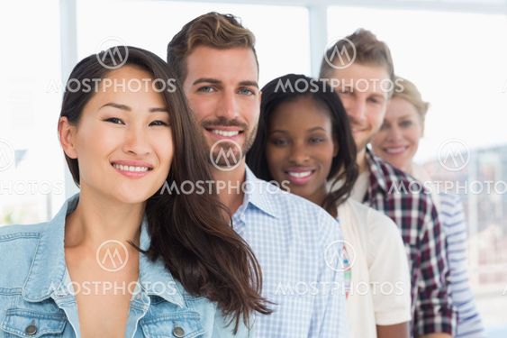 Design team standing in a row smiling at camera