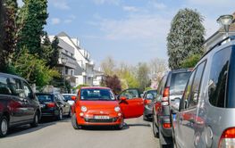 Fiat 500 red car with open door blocking entire street 