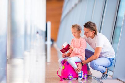 Happy family with luggage and boarding pass at airport...