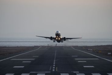Airplane taking off from runway at dusk