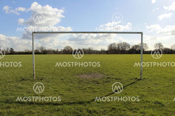 Goal Posts On A Field In The Sun With Blue Sky And Clouds
