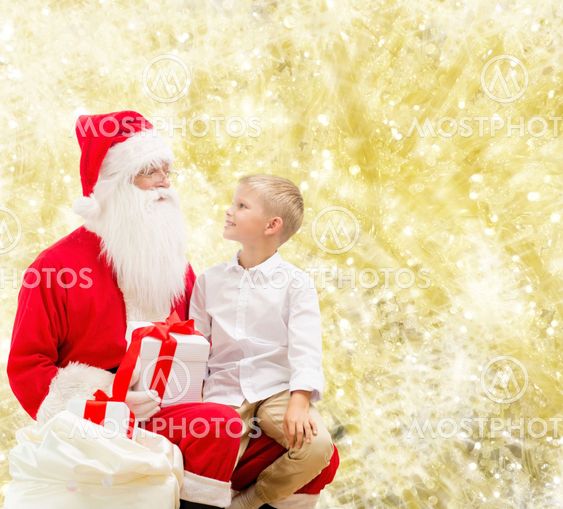smiling little boy with santa claus and gifts