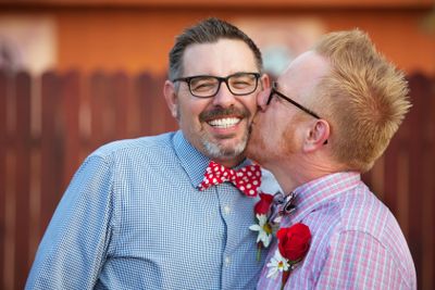 Smiling Man Kissed By Spouse
