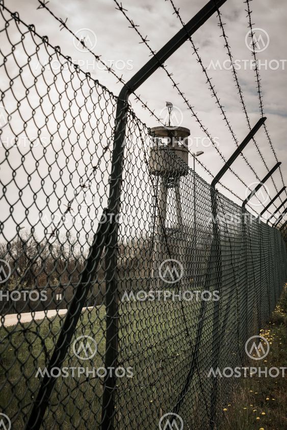Abandoned sentry box tower isolated by a net with barbed...