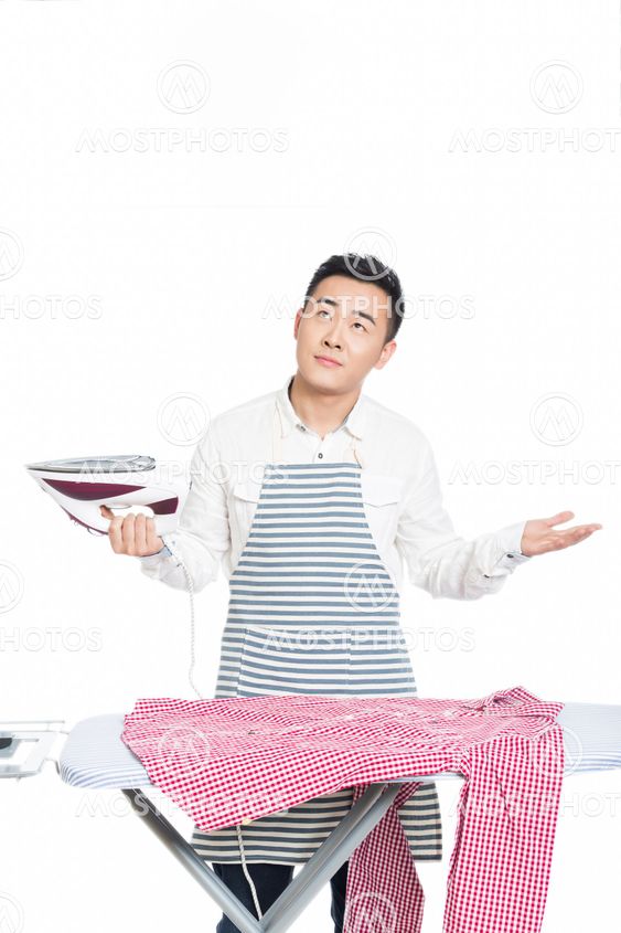 chinese young man ironing his clothes
