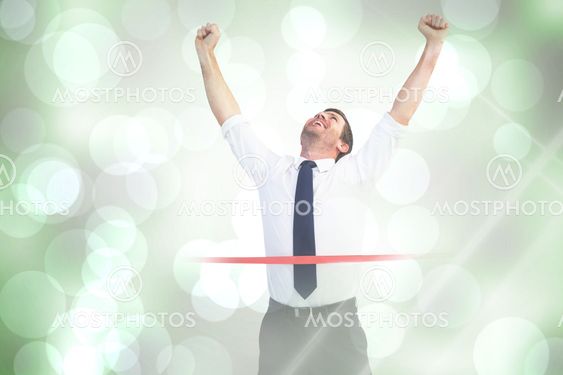 Composite image of businessman celebrating success with arms up