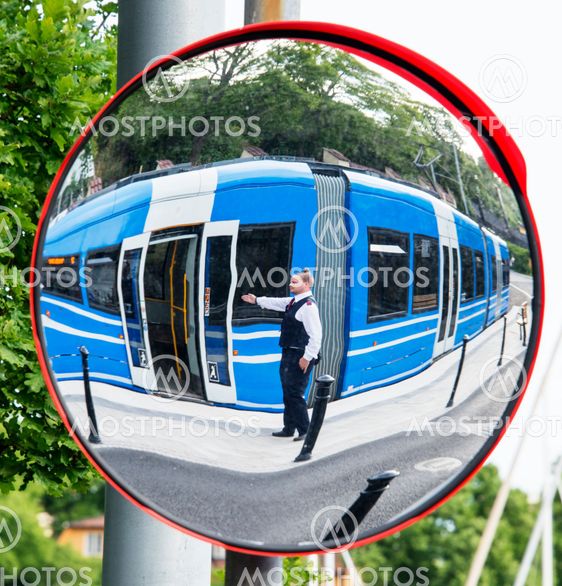 Spårvagnskonduktör hälsar passagerare välkommen in på...